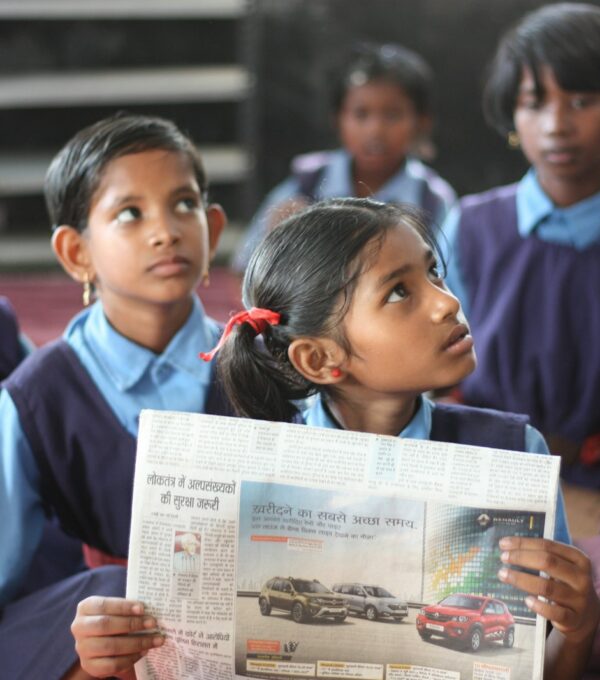 shallow focus photo of girl holding newspaper