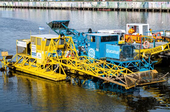 Vibrant machinery on a river engaged in environmental cleanup. Bright and industrial.