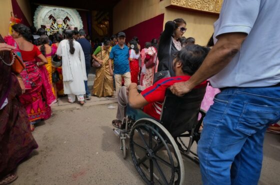 a group of people standing around a man in a wheel chair