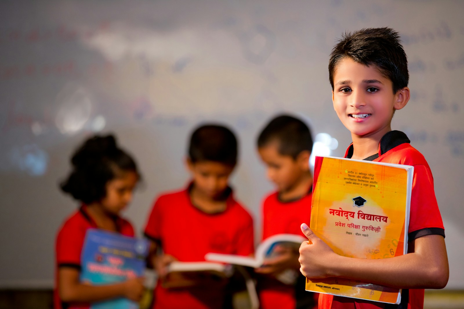Photo by Muhammad Zaid boy in red crew neck shirt holding yellow book