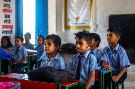 a group of young children sitting in a classroom